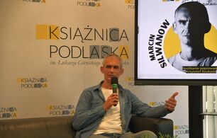 Marcin Silwanow siedzi na kanapie w Galerii Parter.