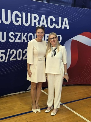 Zdjęcie przedstawiające dwie uśmiechnięte kobiety, Iwonę Gaweł i Monikę Kondratowicz - Sekretarz Województwa Podlaskiego - stojące razem na tle transparentu z napisem "INAUGURACJA ROKU SZKOLNEGO 2025/2026".