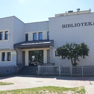 Nowoczesny budynek biblioteki z jasną elewacją, z dużym czarnym napisem 