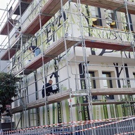 Artyści znajdują się na rusztowaniach i malują mural.