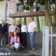 Komisja odbiorowa oraz wykonawcy stoją przed muralem „Książki do nieba” podczas jego odbioru.